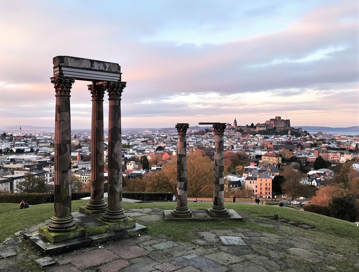 The unfinished classical monument on Calton Hill at dawn with the old town below
