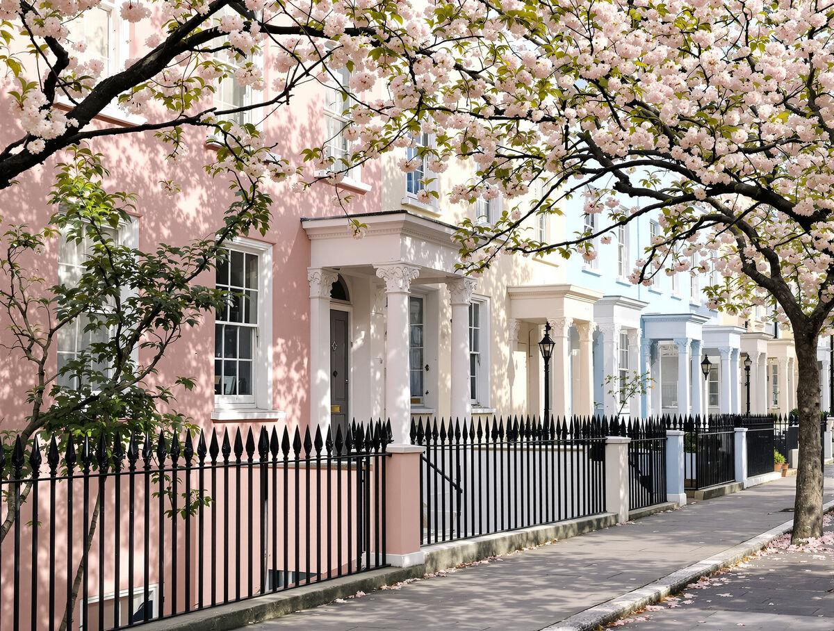 A row of pastel Georgian terraces on a quiet London street with a cherry tree in blossom